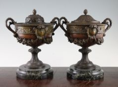 A pair of late 19th / early 20th century French painted spelter two handled urns, on stepped green