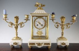 An early 20th century French ormolu mounted white marble three piece clock garniture, the four glass