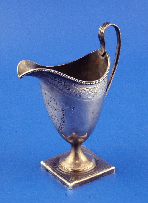 A George III silver helmet shaped cream jug by Peter & Ann Bateman, with engraved monogram, beaded