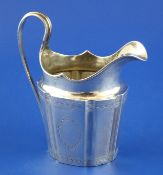 A George III Irish silver helmet shaped cream jug, with loop handle and engraved borders and