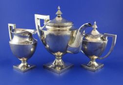 An early 20th century Chinese three piece silver pedestal tea set by Wing On & Co, Hong Kong, of urn