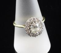 An 18ct gold and diamond cluster ring, of oval shape, with central oval cut diamond weighing