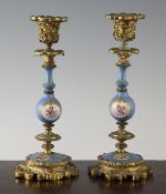 A pair of 19th century French ormolu and Sevres porcelain candlesticks, decorated with cherubs and