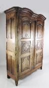 A 19th century provincial French walnut and elm two door armoire, the double arched top with a