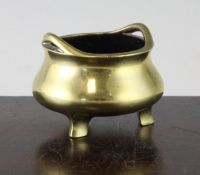 A Chinese bronze tripod censer, 19th century, of compressed baluster form with a pair of looped