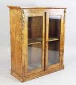 A Victorian burr walnut pier cabinet, with ormolu mounts and fitted a pair of glazed doors, on