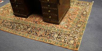 A Heriz rug, with field of geometric foliate motifs on a red ground with three row border, 8ft 5in