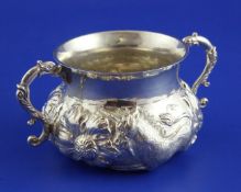 A George V Carolean style silver porringer, with scroll handles and embossed with lion, unicorn and