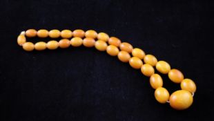 A single strand graduated oval amber bead necklace, gross weight 78 grams, 21.5 in.