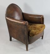 A 1930`s French tan leather club armchair, with brass studded decoration and gothic shaped back