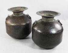 A large near pair of ovoid Indian spot hammered copper vases, with flared necks and ring handles,