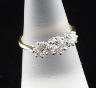An 18ct gold and platinum graduated three stone diamond ring, with an approximate total diamond