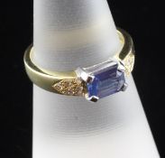 A 18ct gold sapphire and diamond dress ring, with emerald cut sapphire flanked by brilliant set