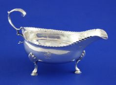 A George III silver sauceboat by Hester Bateman, with flying scroll handle, engraved armorial and
