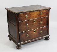 A late 17th / early 18th century small oak chest, of three long drawers, with bun feet and brass