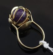 An unusual 1970`s gold and amethyst dress ring, the spherIcal amethyst mounted in a revolving