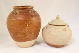 A Thai Sawankhalok potiche and cover, 15th century and a Tang dynasty pottery jar, the potiche with