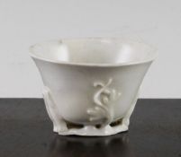 A Chinese blanc-de-chine libation cup, Dehua, 17th century, of typical form moulded with flower