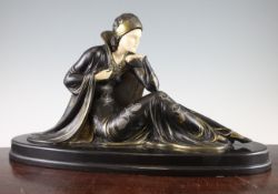 A French Art Deco bronzed spelter and ivorine figure of a seated lady, signed Menneville, on oval