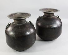 A large near pair of ovoid Indian spot hammered copper vases, with flared necks and ring handles,
