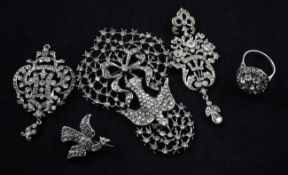 Four 19th century silver and white paste set brooches and a ring, including a pierced scrolling