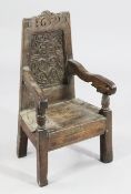 A 17th century carved oak child`s high chair, carved with the initials TC and dated 1659For similar