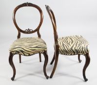 A set of six Victorian walnut dining chairs, the open oval backs with floral carved decoration and
