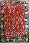 An Iranian Royal Kashan carpet, with field of scrolling foliage on a red ground, with ornate