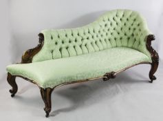 A Victorian carved rosewood chaise longue, with buttoned green floral fabric and serpentine shaped