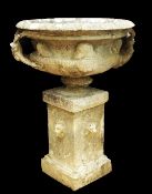 A large reconstituted stone circular two handled garden urn, on square plinth base with lion mask