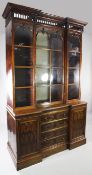 A late Regency rosewood inverted breakfront bookcase, with arcaded pierced pediment above three