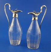 A pair of George III silver mounted panelled glass cruet bottles, with engraved armorial and loop