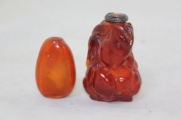 Two similar Chinese amber cylindrical snuff bottles, 1800-1900, each carved in relief with lion