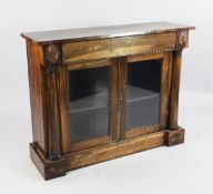 A 19th century rosewood bookcase, fitted a pair of glazed cupboard doors between tapering