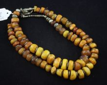 Two single strand amber bead necklaces, both strung with white metal dividers, 24in et infra.