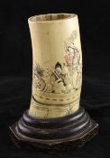 A Japanese ivory tusk vase, Meiji period, tinted and relief carved with figures of a boat with a