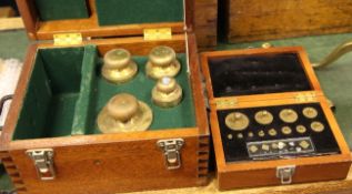 A cased set of brass cylindrical metric working standard weights, 5kg to 1mg, the lid with brass