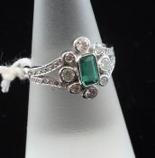 An 18ct white gold, emerald and diamond cluster ring, with pierced shoulders, size M.