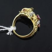 An Indian gold, enamel and gem set ""dolphin"" ring, set with rubies and old cut diamonds, size O.