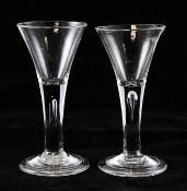 A pair of airtrap stem wine glasses, the funnel shaped bowls above teardrop stems, on folded feet,