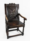 A 17th century carved oak wainscot armchair, with lunette and stylised leaf carved panel back and