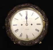 Frodsham & Baker of London. A Victorian oak cased wall clock, the circular case carved with laurel