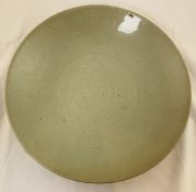 A Chinese Ming celadon dish, Swatow 17th century, the cavetto with four continuous incised floral