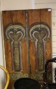 A pair of Indonesian polychrome and carved wood temple doors, Madura, 19th century, each with