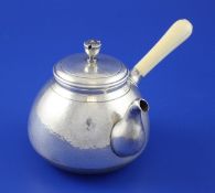 A 20th century Japanese silver teapot, of bulbous form, with ivory handled, planished body and