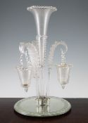 A Victorian glass epergne, the circular mirrored base supporting a central trumpet vase with spiral