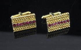 A pair of 14ct gold and ruby cufflinks, of rectangular form, each set with single row of seven