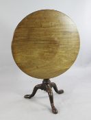A George III mahogany circular tripod table, with birdcage movement, gun barrel support and