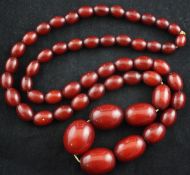 A single strand graduated simulated red amber bead necklace, gross weight 86 grams, 32in.