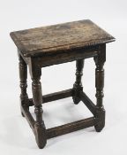 A 17th century oak joynt stool, with a rectangular pegged top and channel moulded frieze, on ring